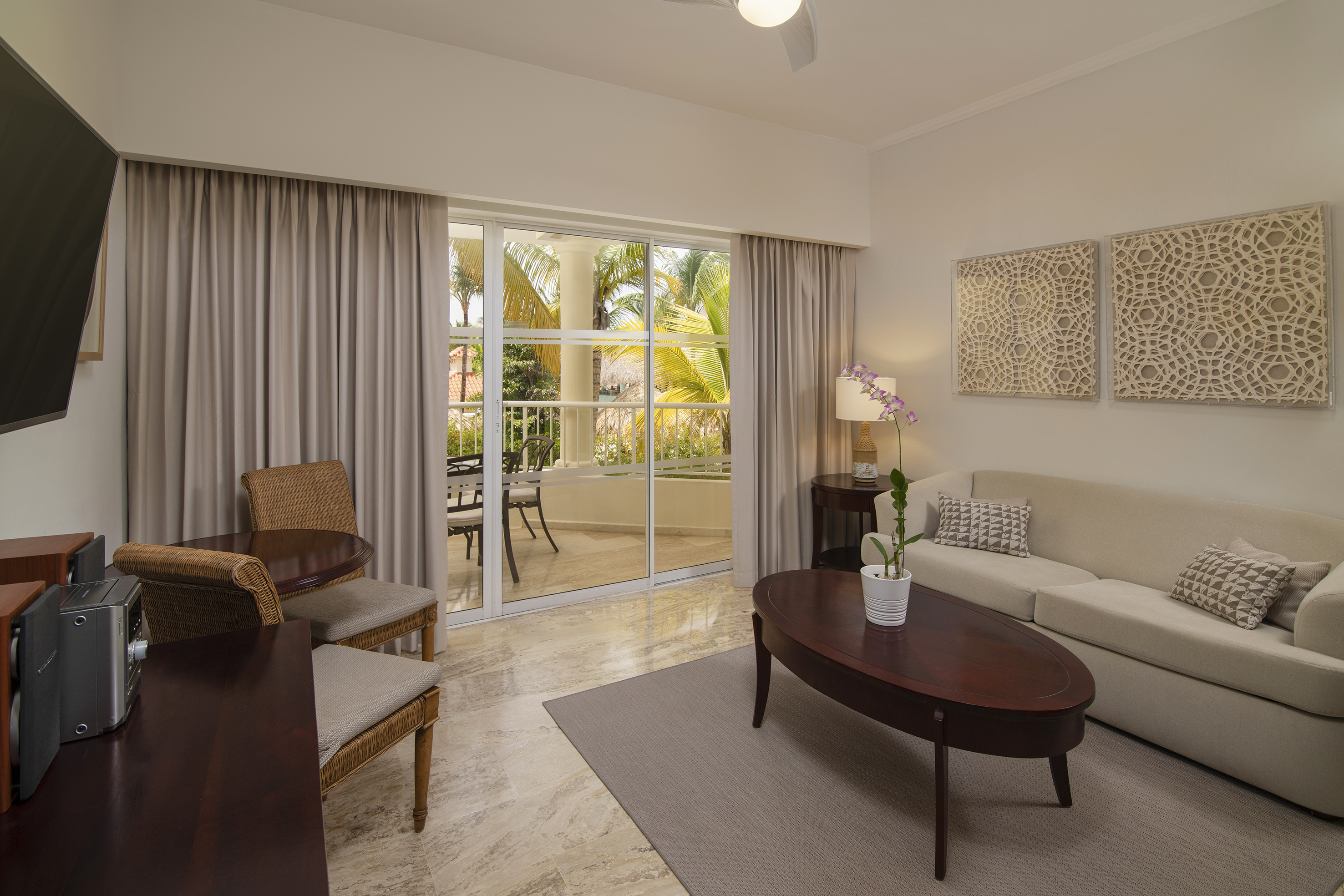 Modern hotel living room with tropical balcony view and comfortable sofa.