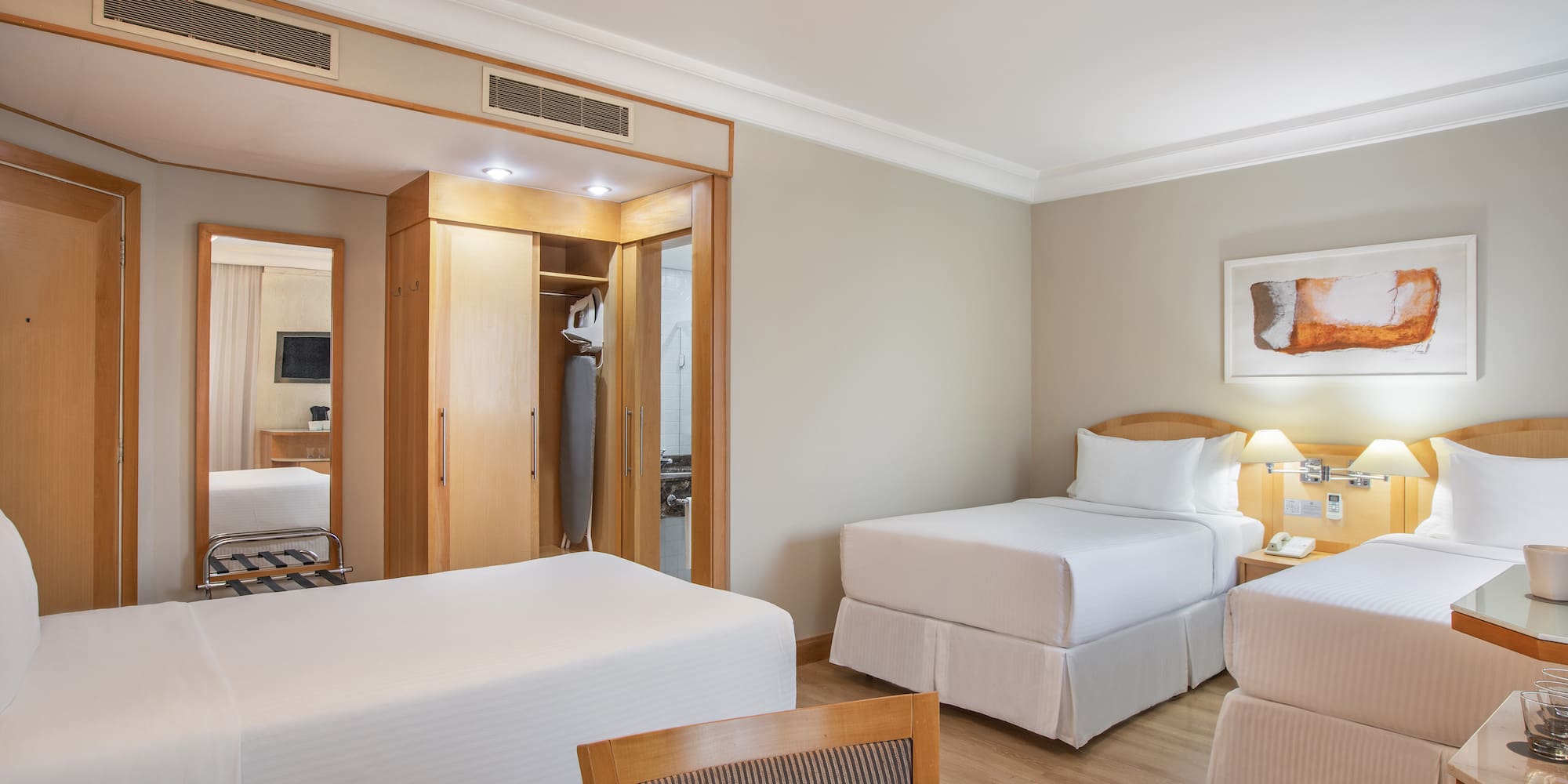 a room with two beds and a mirror