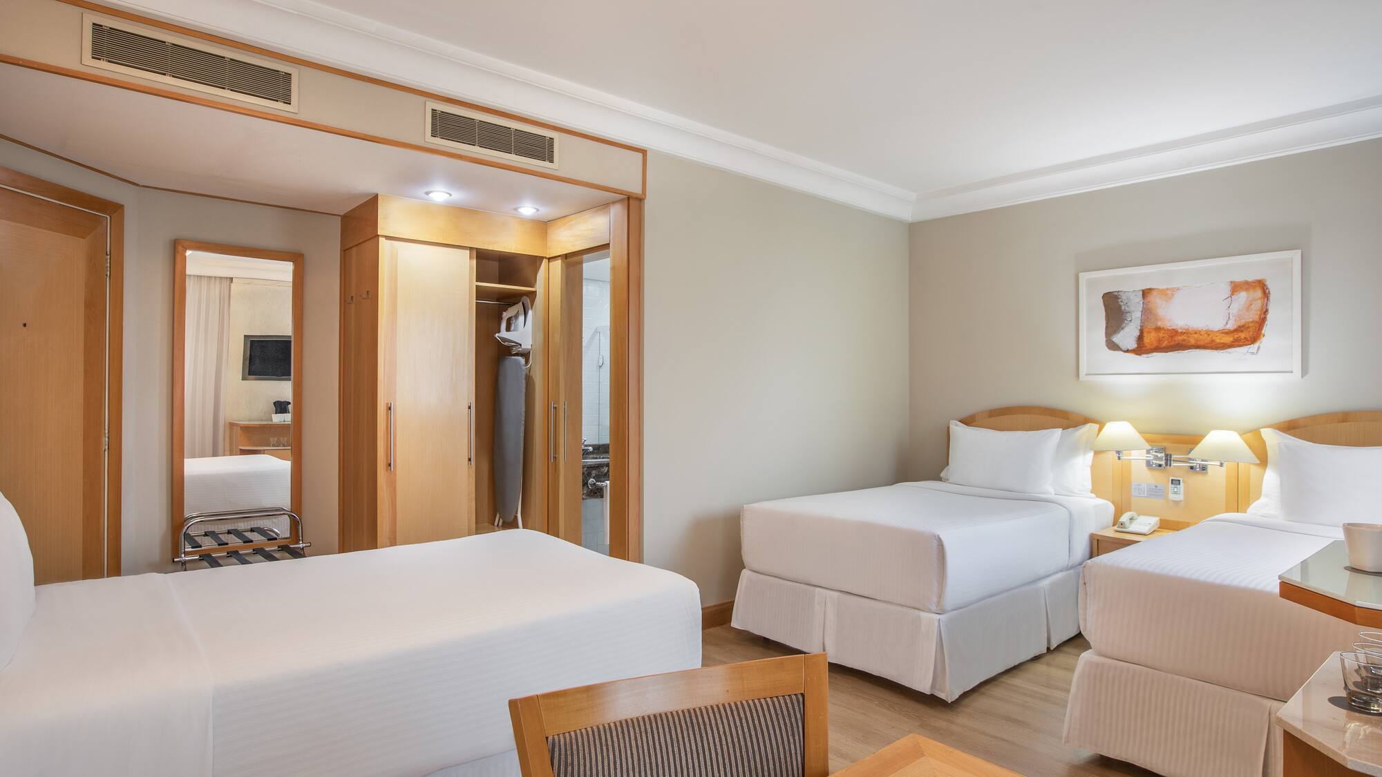 a room with two beds and a mirror