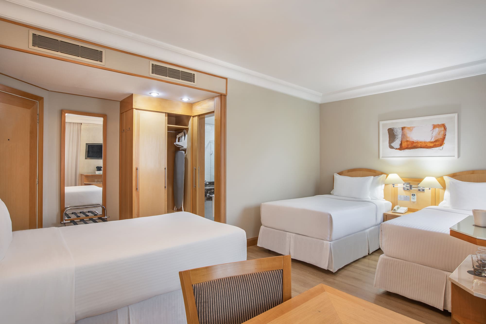 a room with two beds and a mirror