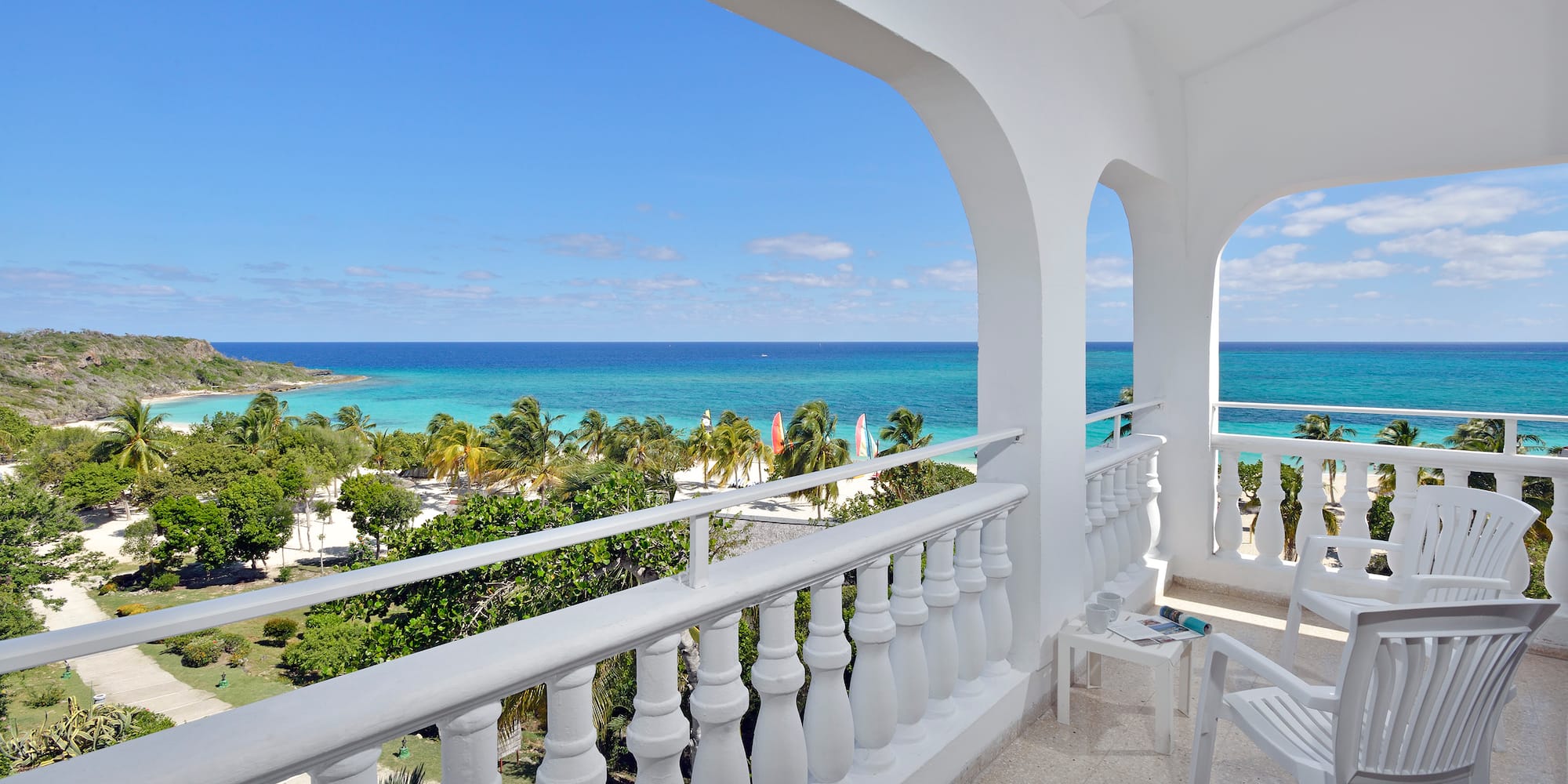 a balcony with a view of the ocean and trees