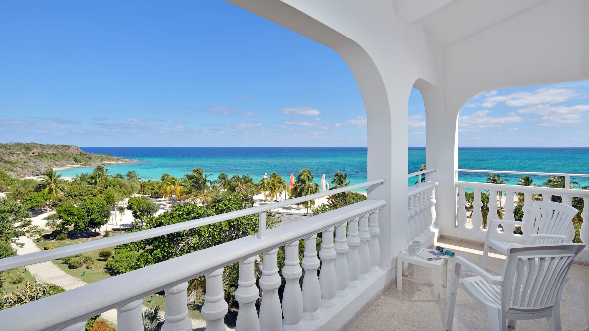 a balcony with a view of the ocean and trees