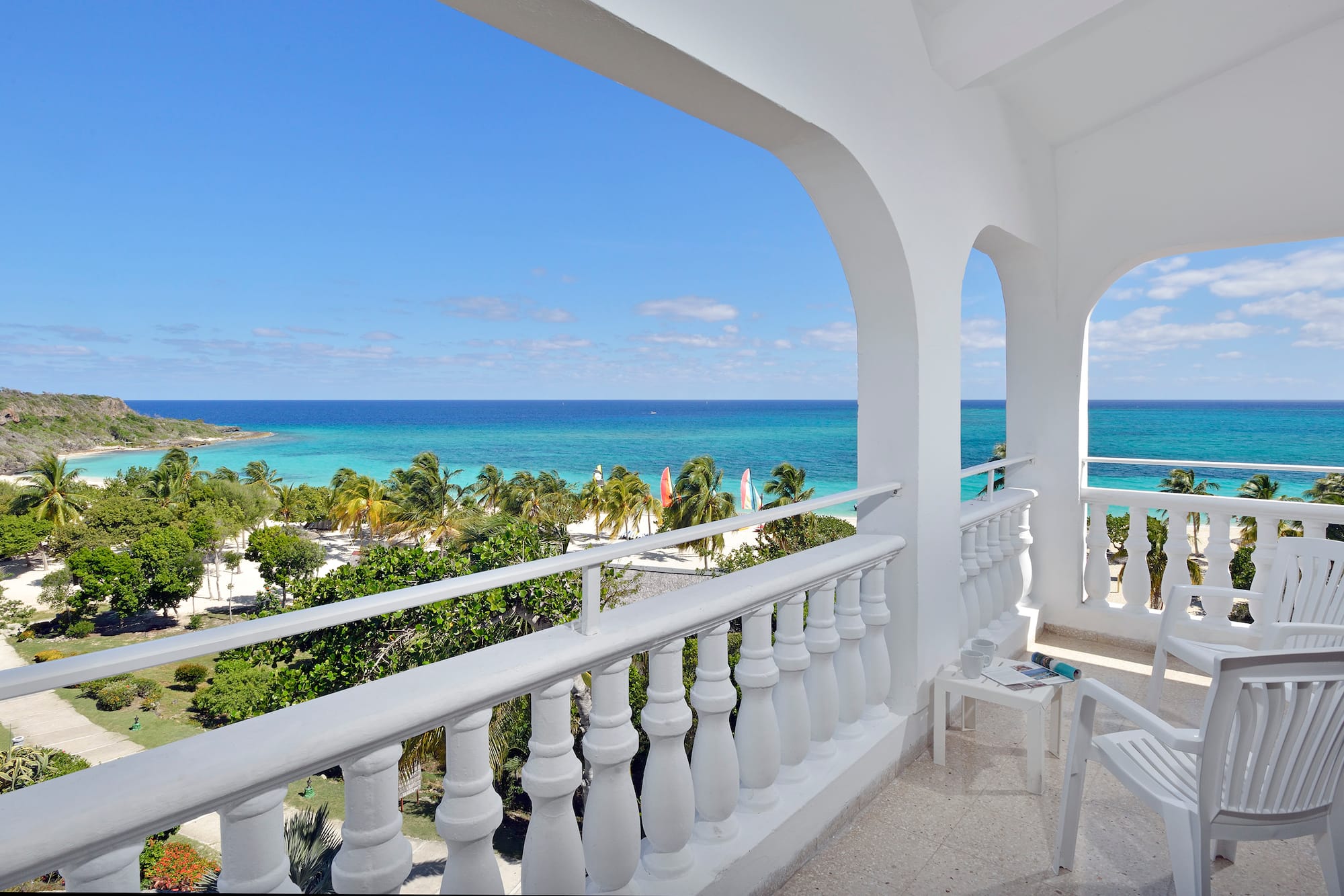 a balcony with a view of the ocean and trees