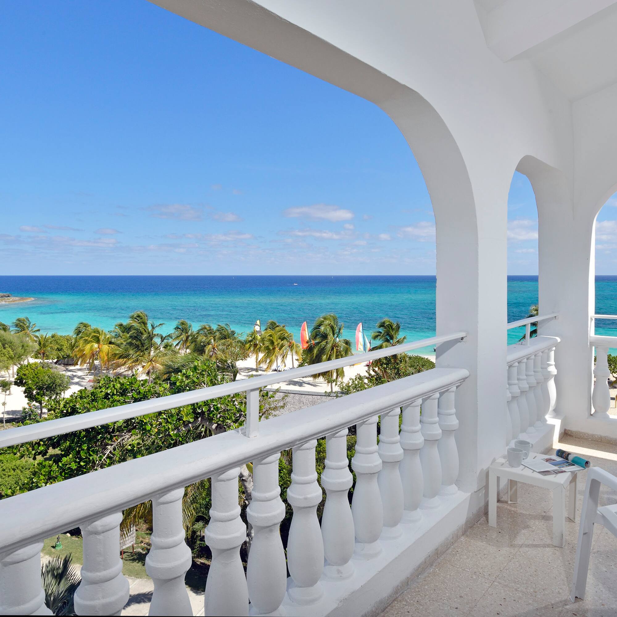 a balcony with a view of the ocean and trees