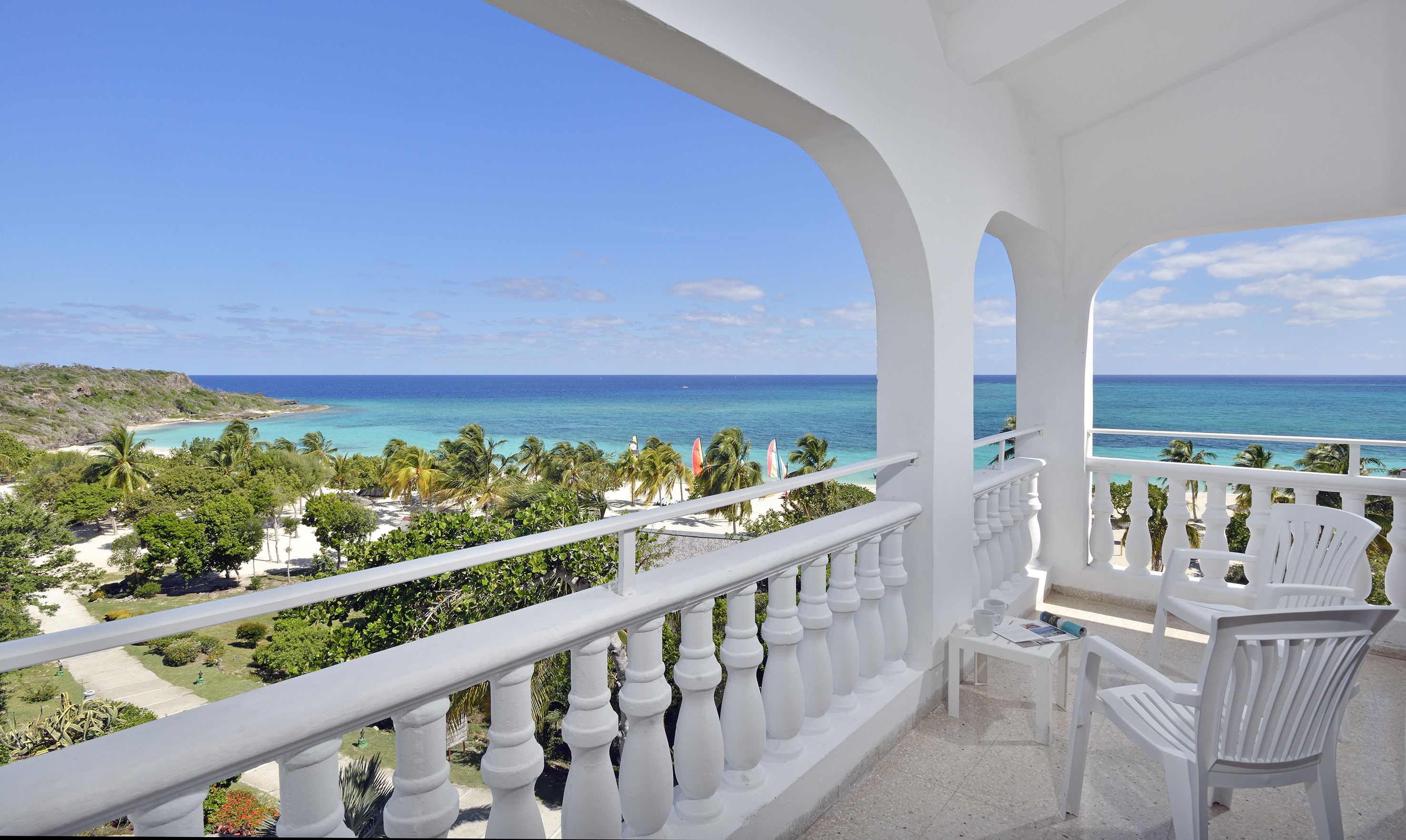 a balcony with a view of the ocean and trees