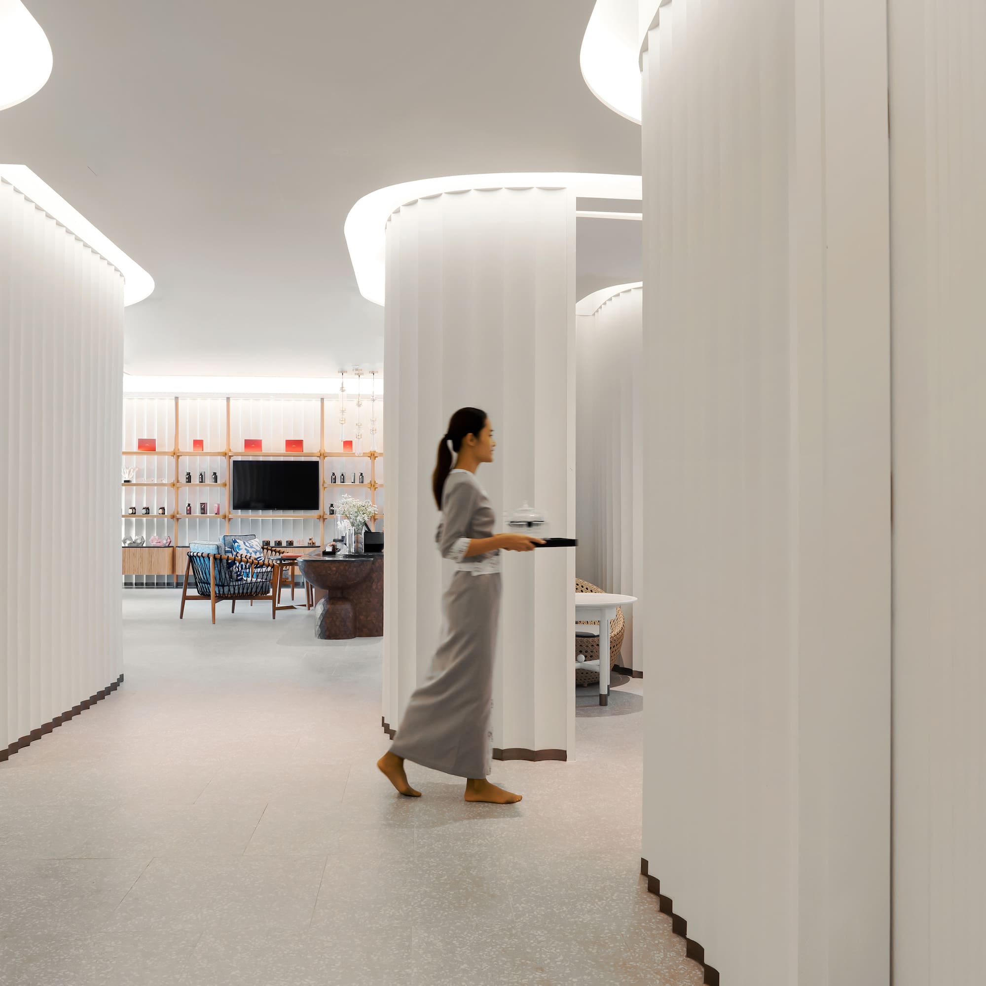 a woman walking in a room with columns