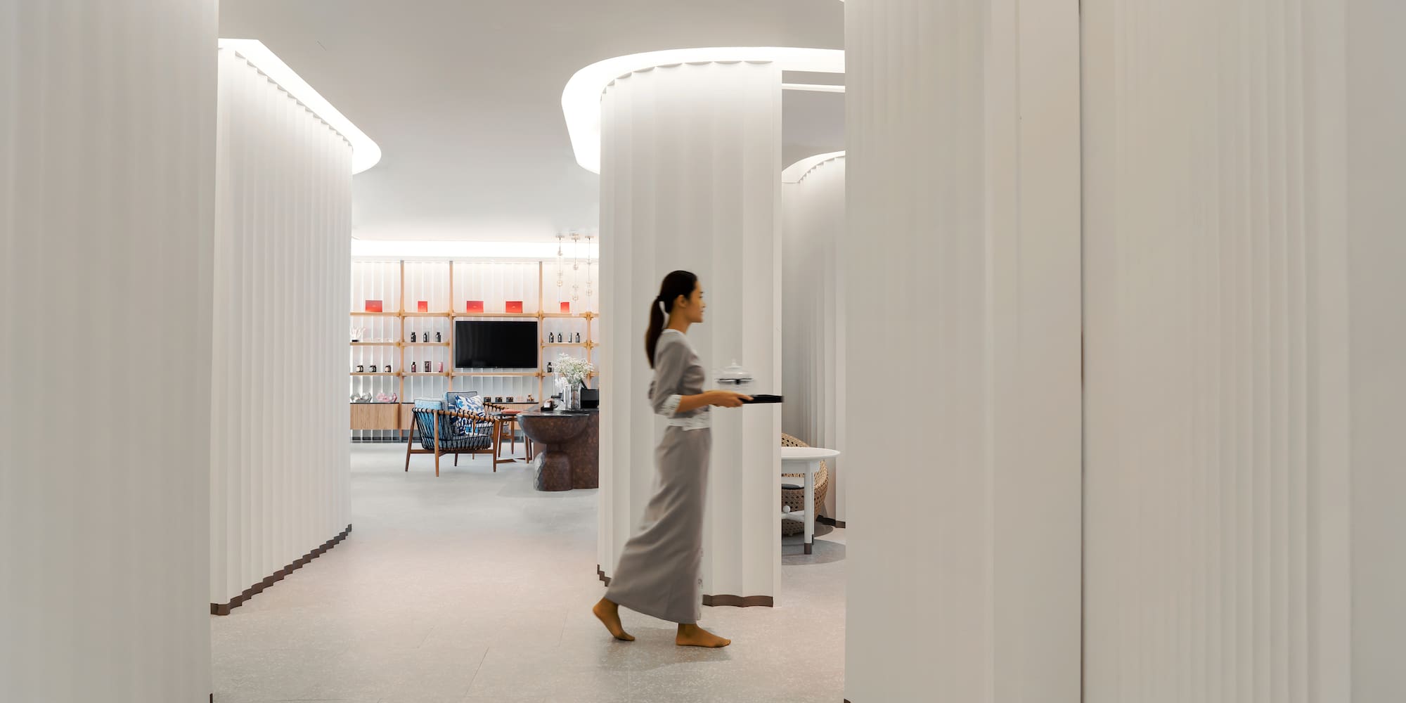 a woman walking in a room with columns