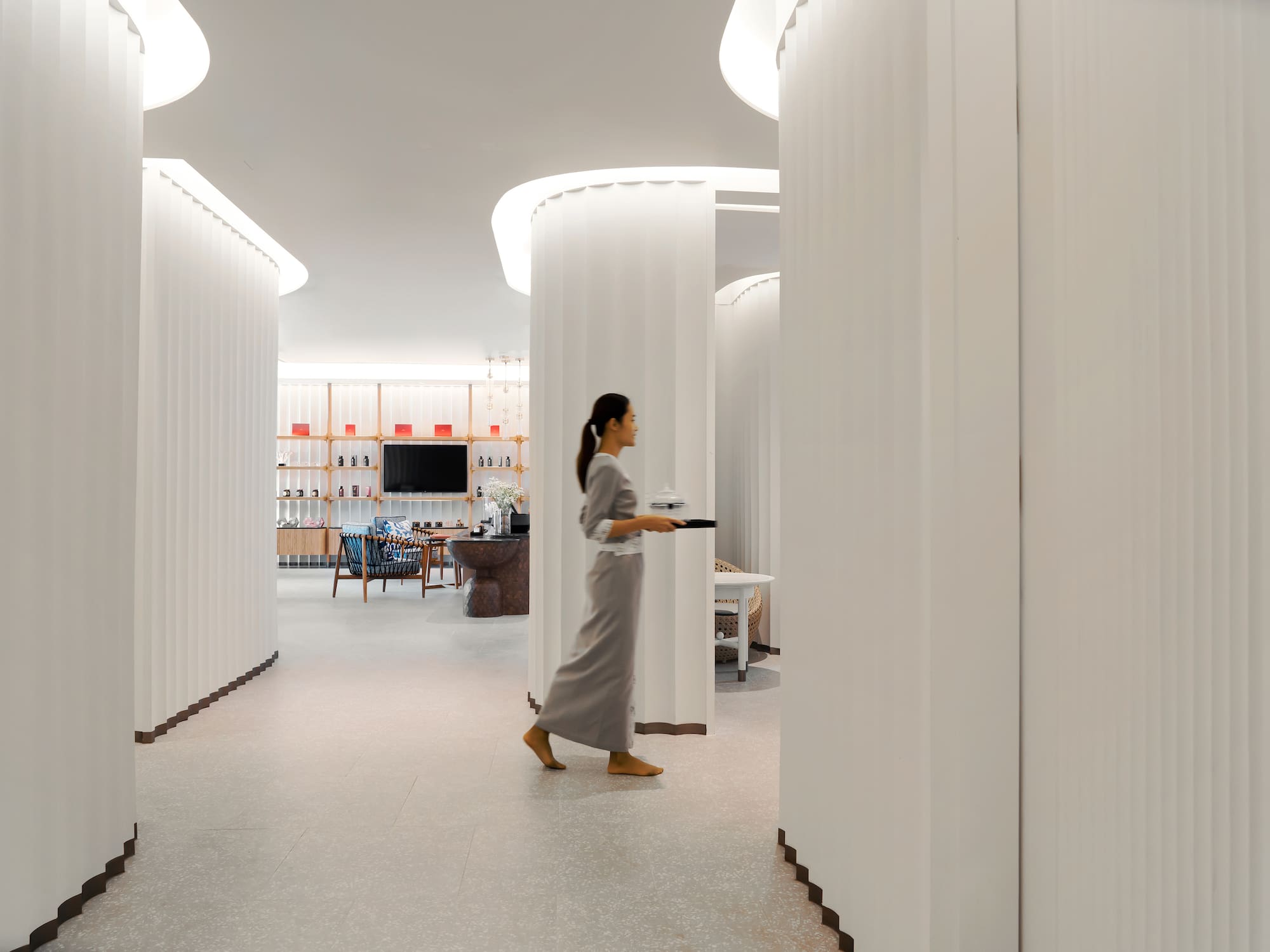 a woman walking in a room with columns