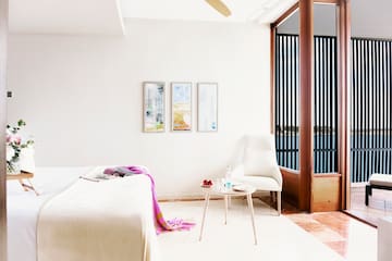 a bedroom with a bed and a table and chairs