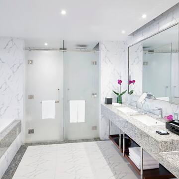 a bathroom with marble countertop sinks and a shower