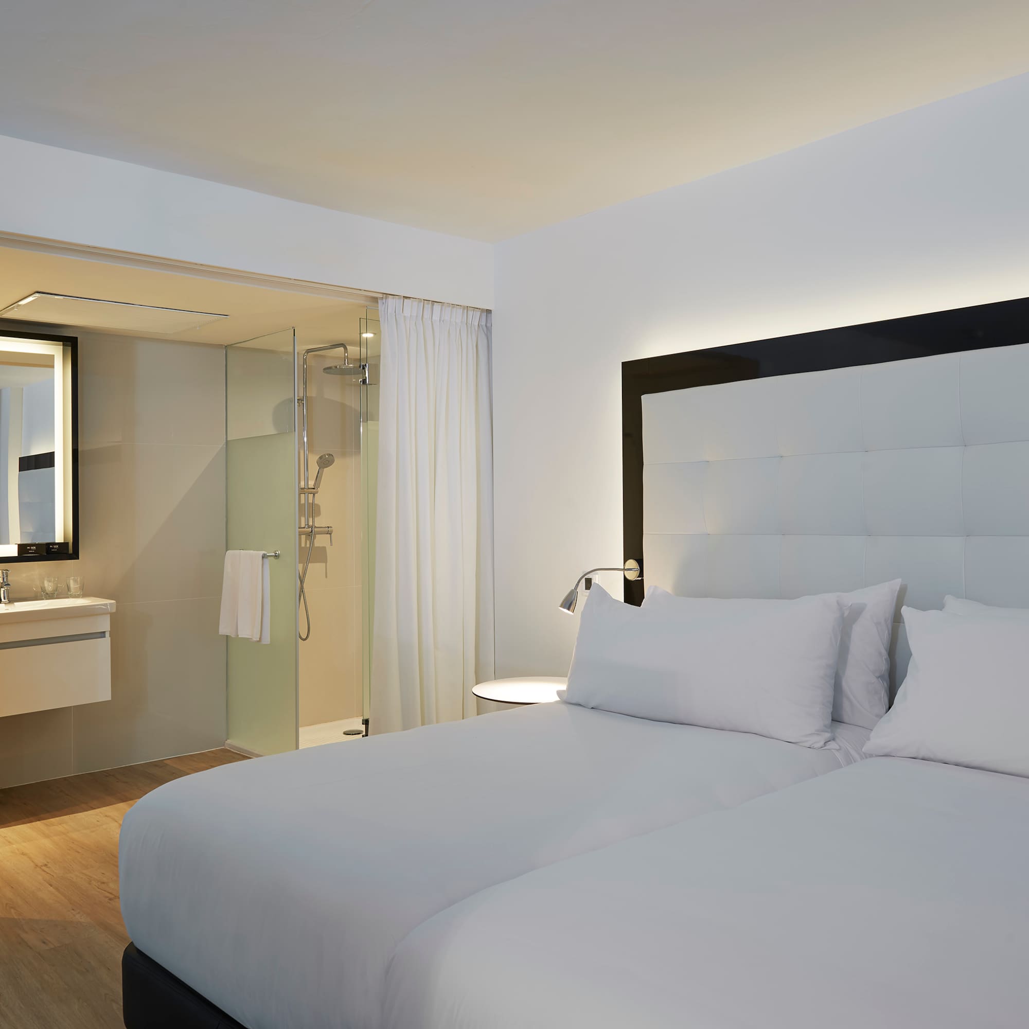 a hotel room with a double bed and a shower