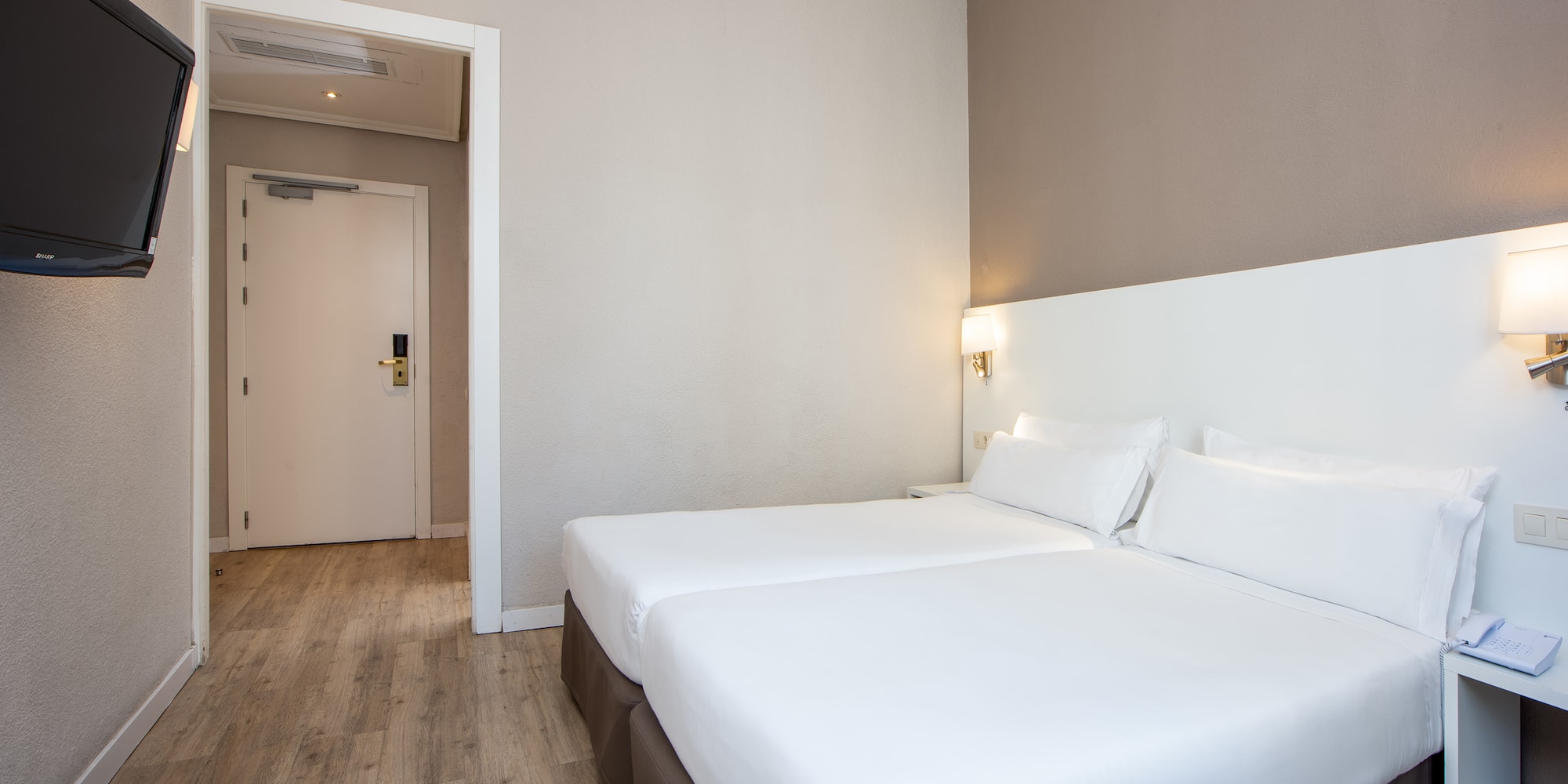 a room with two beds and a wood floor