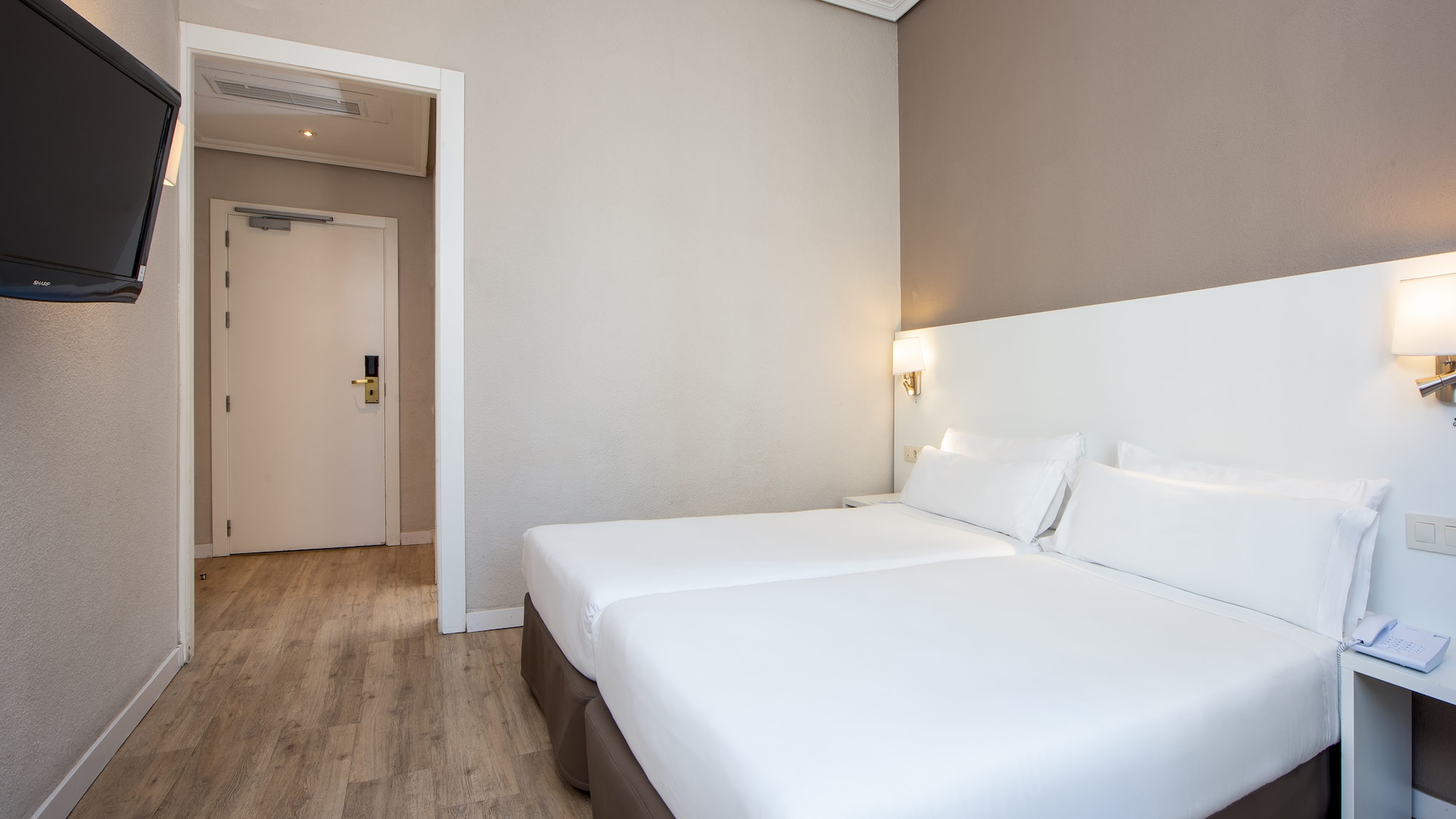 a room with two beds and a wood floor