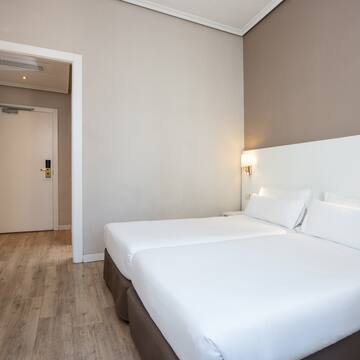a room with two beds and a wood floor