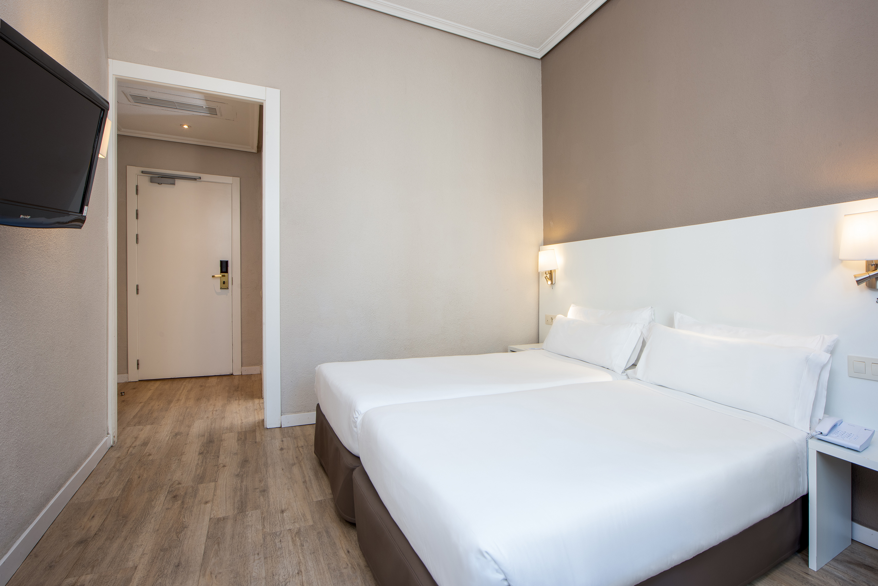 a room with two beds and a wood floor