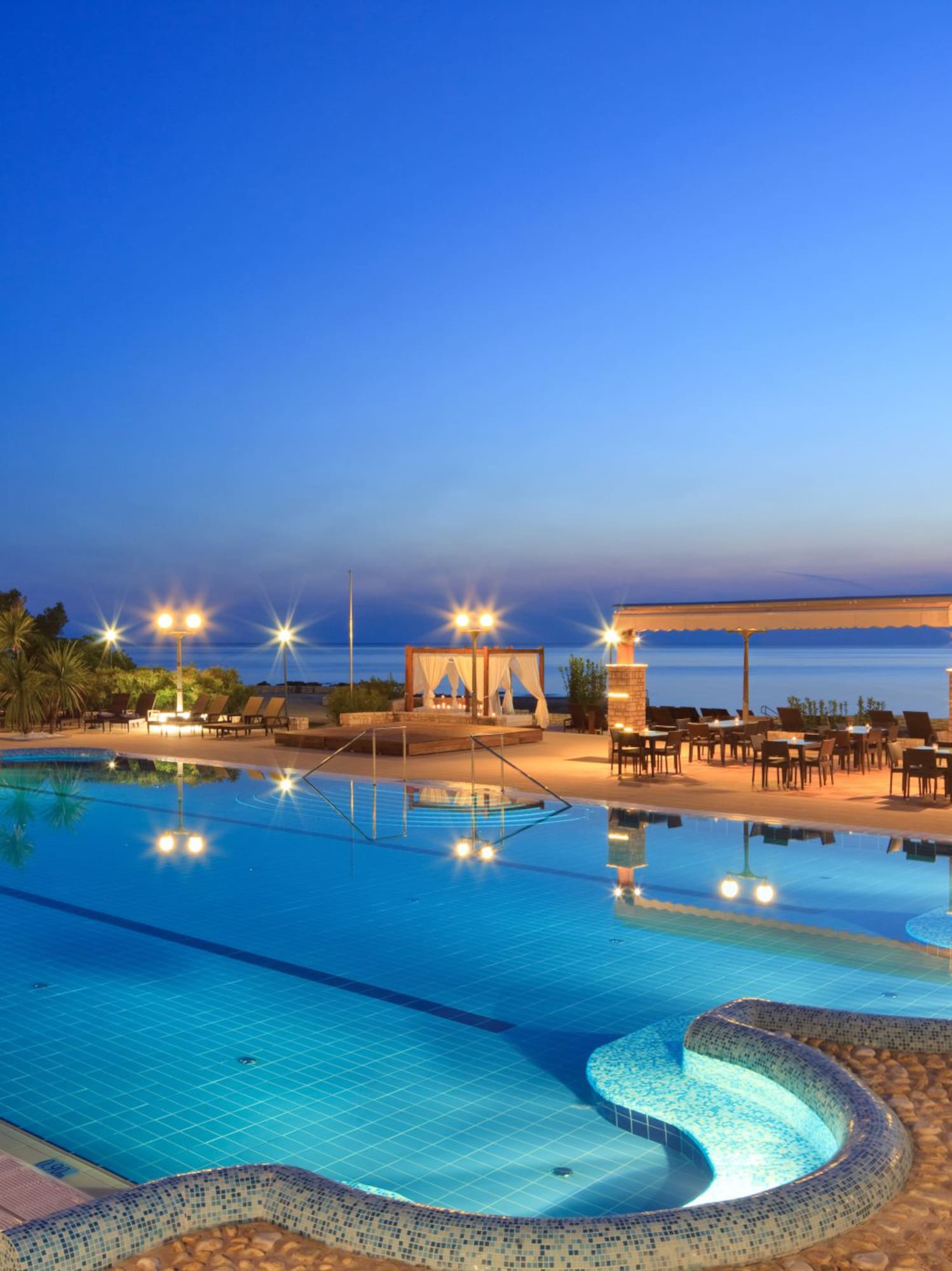 a swimming pool with a gazebo and chairs