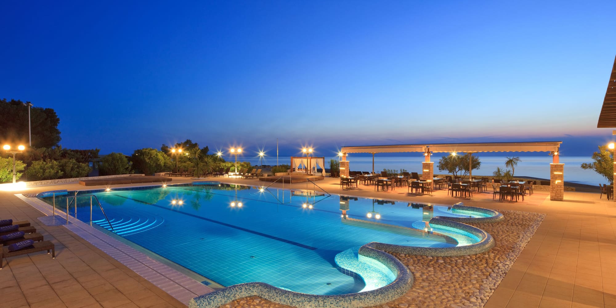 a swimming pool with a gazebo and chairs