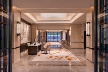 a lobby with a large rug and chairs