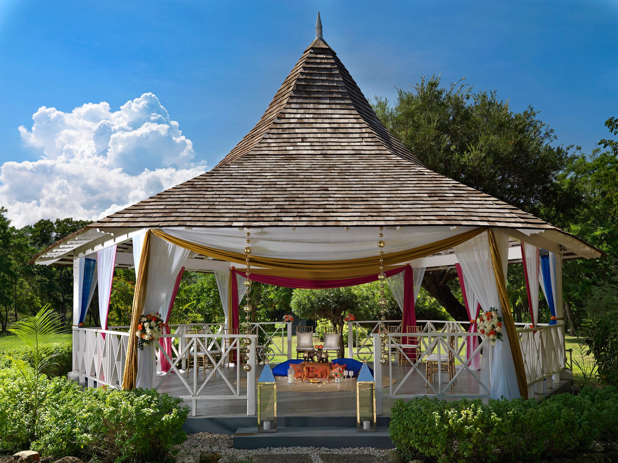 a gazebo with a table and chairs with Global Vipassana Pagoda in the background