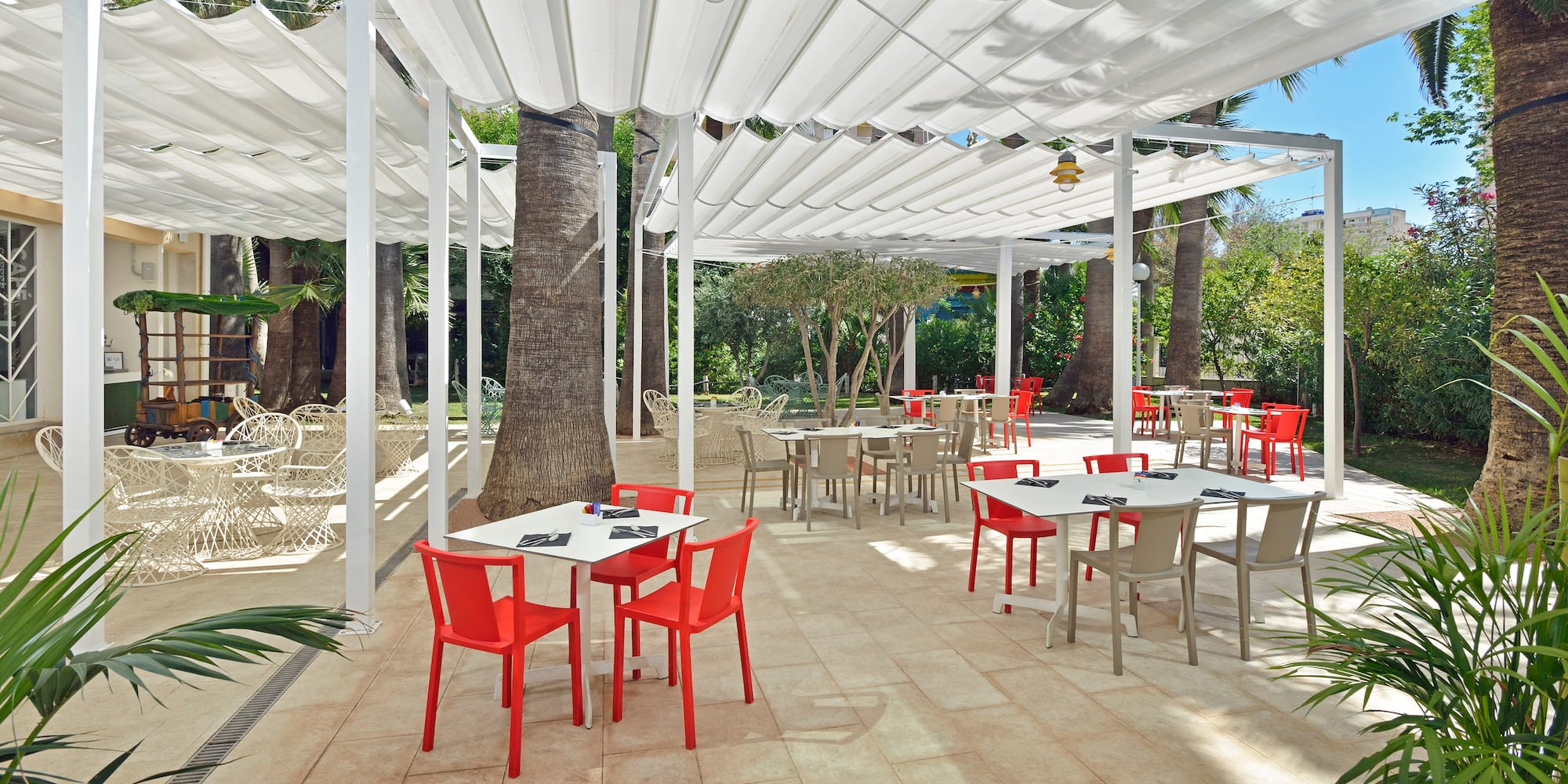 a white covered patio with tables and chairs