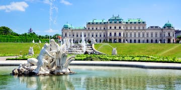 a fountain in front of a large building with Belvedere, Vienna in the background