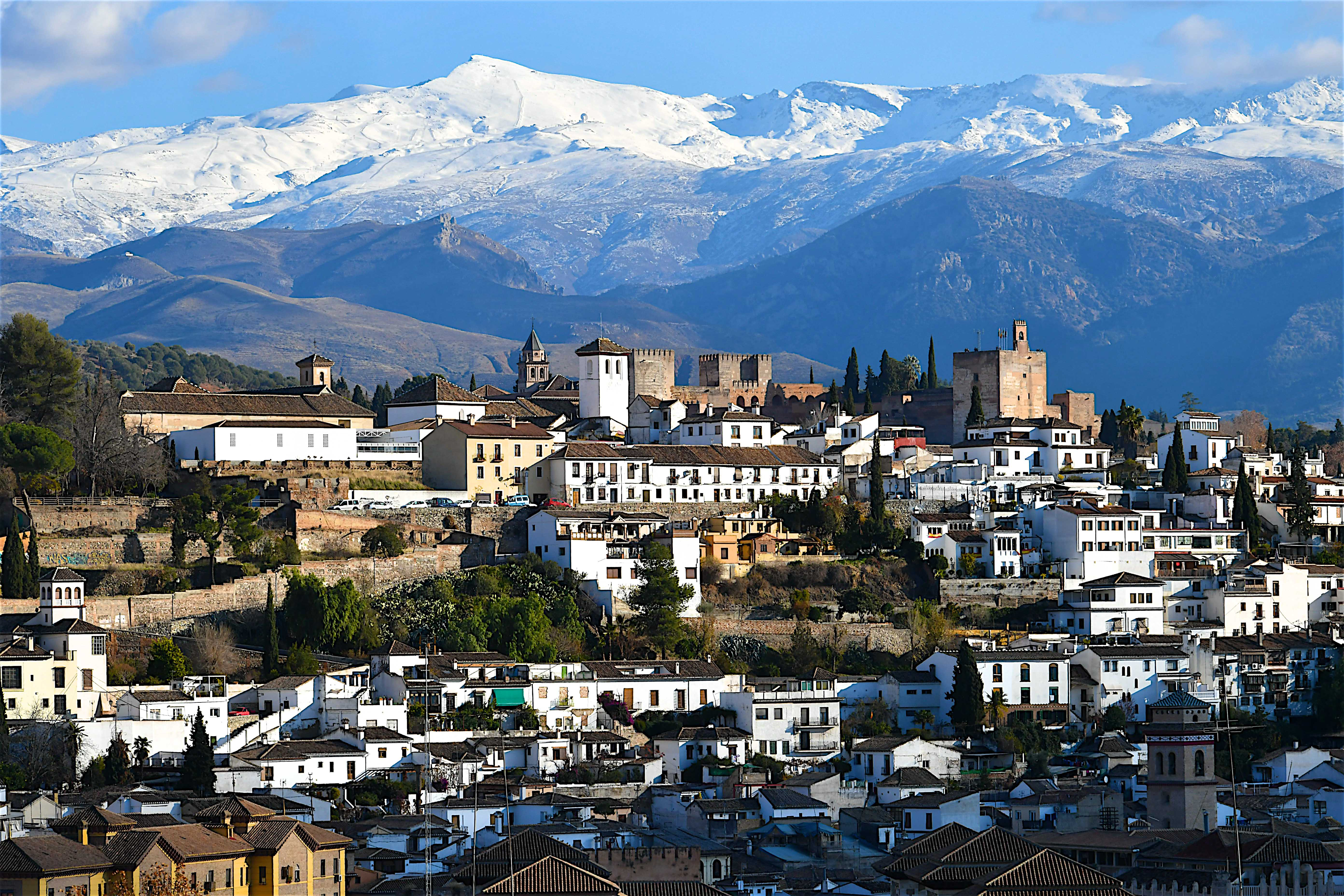 Granada city, white buildings, Alhambra fortress, Sierra Nevada snow mountains.