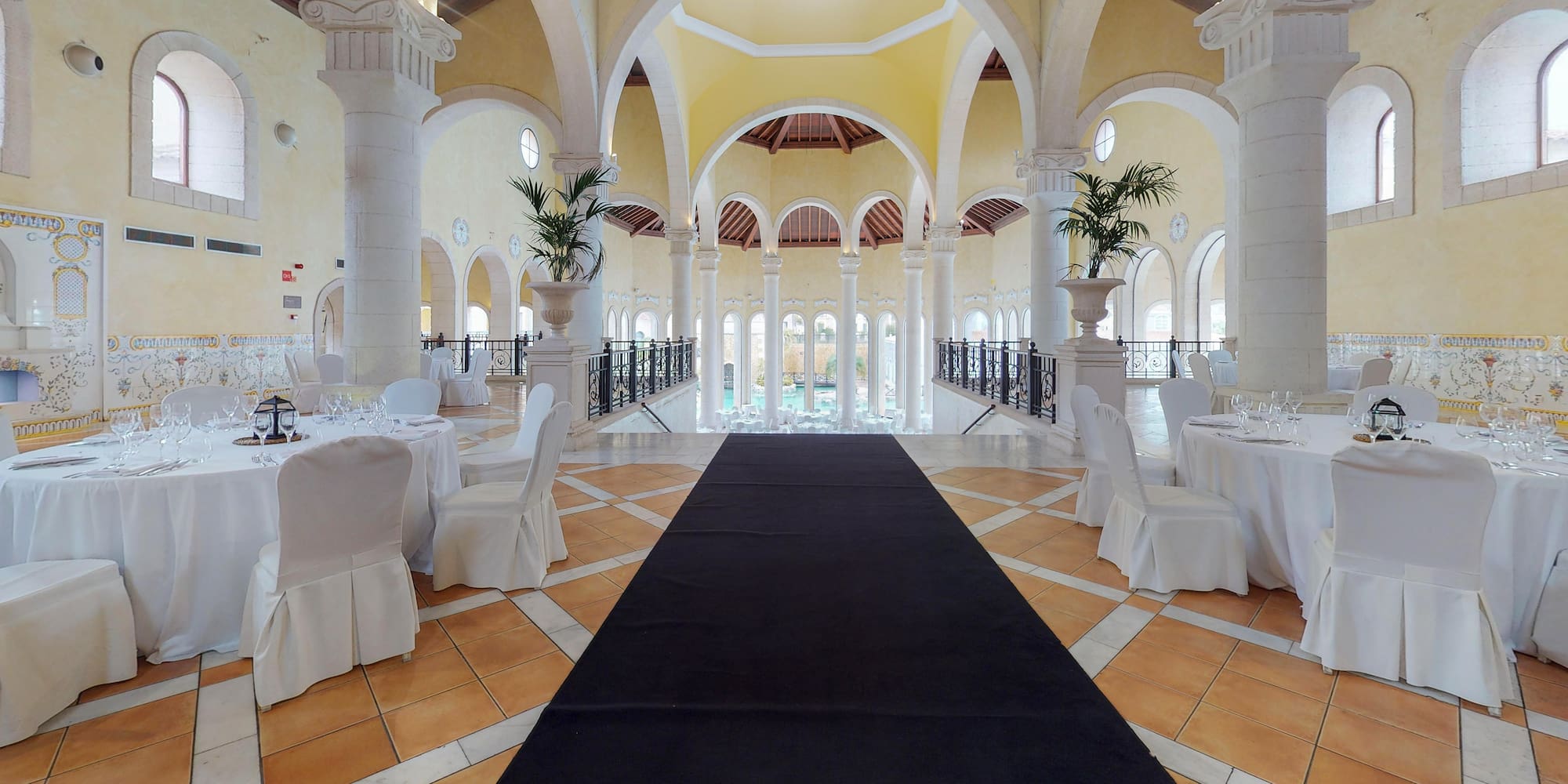 a long black carpet in a room with white tables and chairs