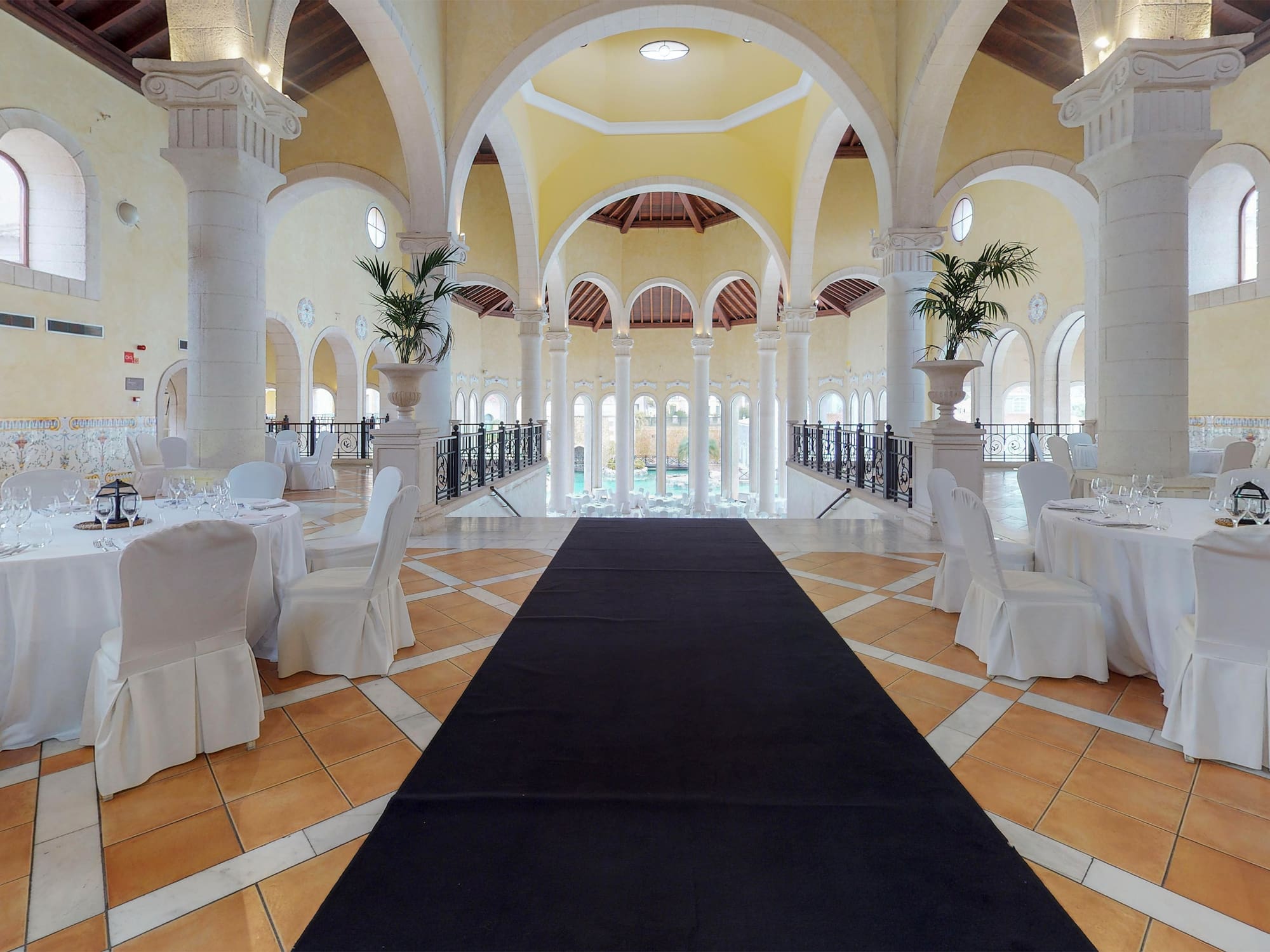 a long black carpet in a room with white tables and chairs