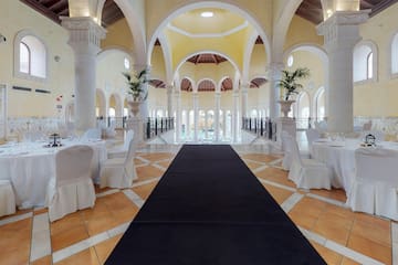 a long black carpet in a room with white tables and chairs