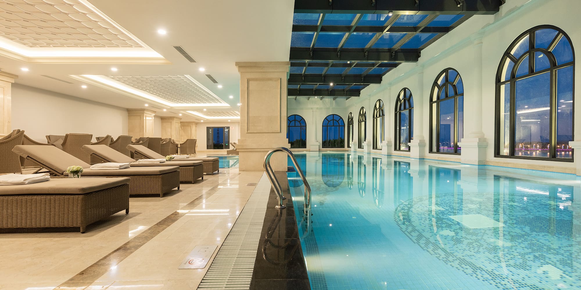 a indoor pool with chairs and a ceiling