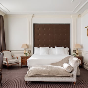 a bedroom with a bed and chairs