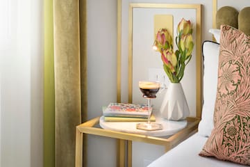 a coffee cup on a table next to a vase of flowers