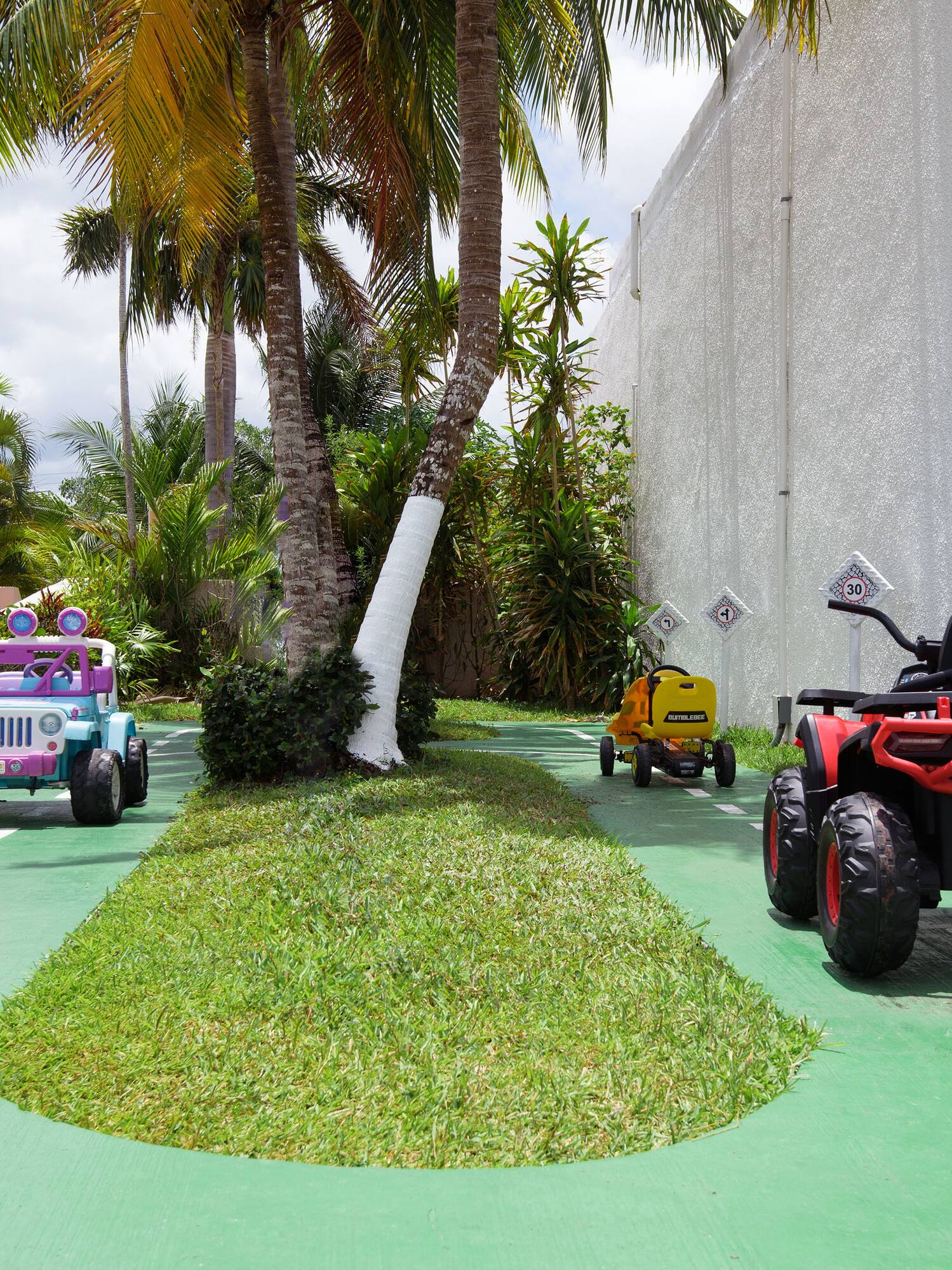 a group of toy cars on a green road
