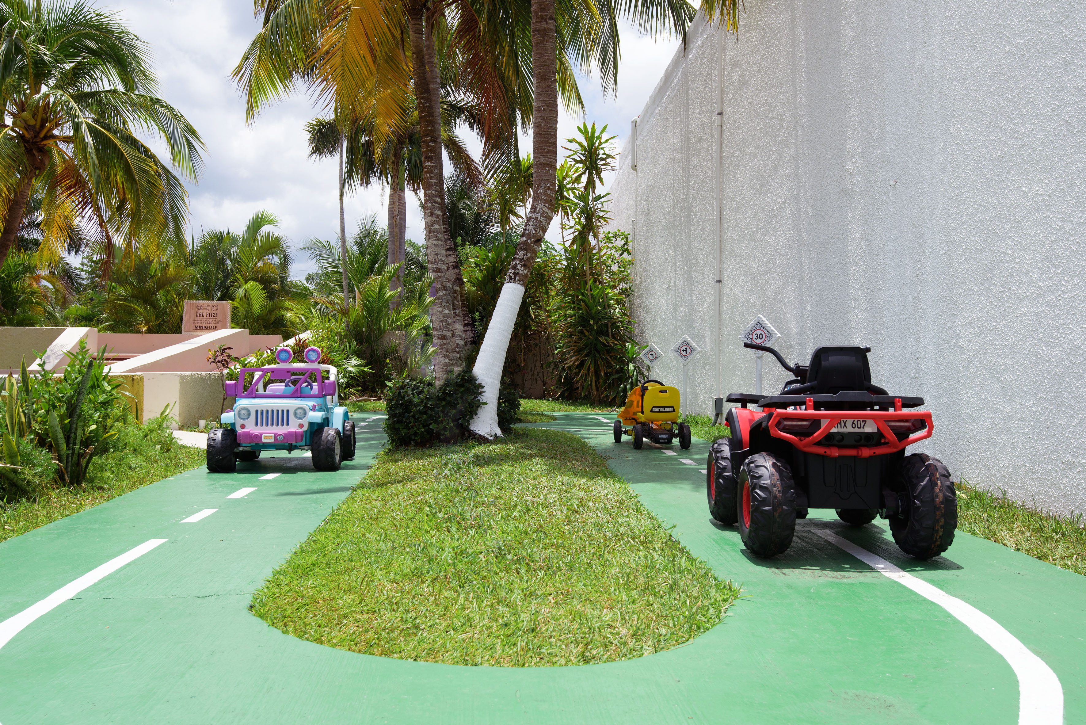 a group of toy cars on a green road