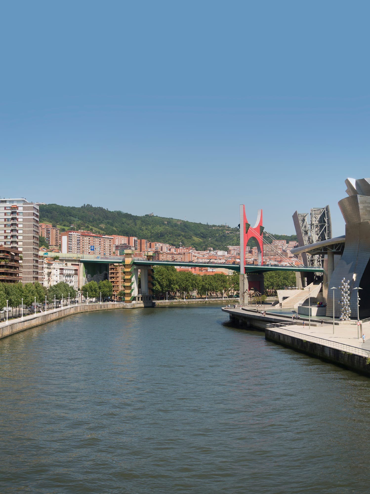 a river with a bridge and buildings in the background