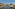 a river with a bridge and buildings in the background