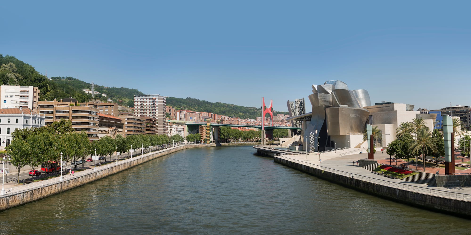 a river with a bridge and buildings in the background