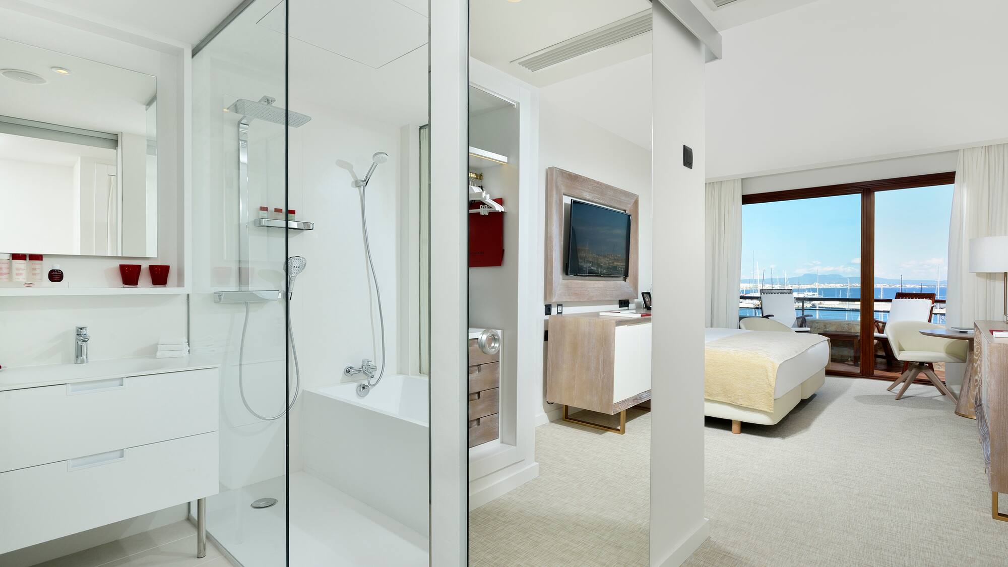 a bathroom with a glass shower and a bed