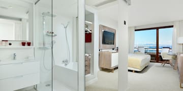 a bathroom with a glass shower and a bed