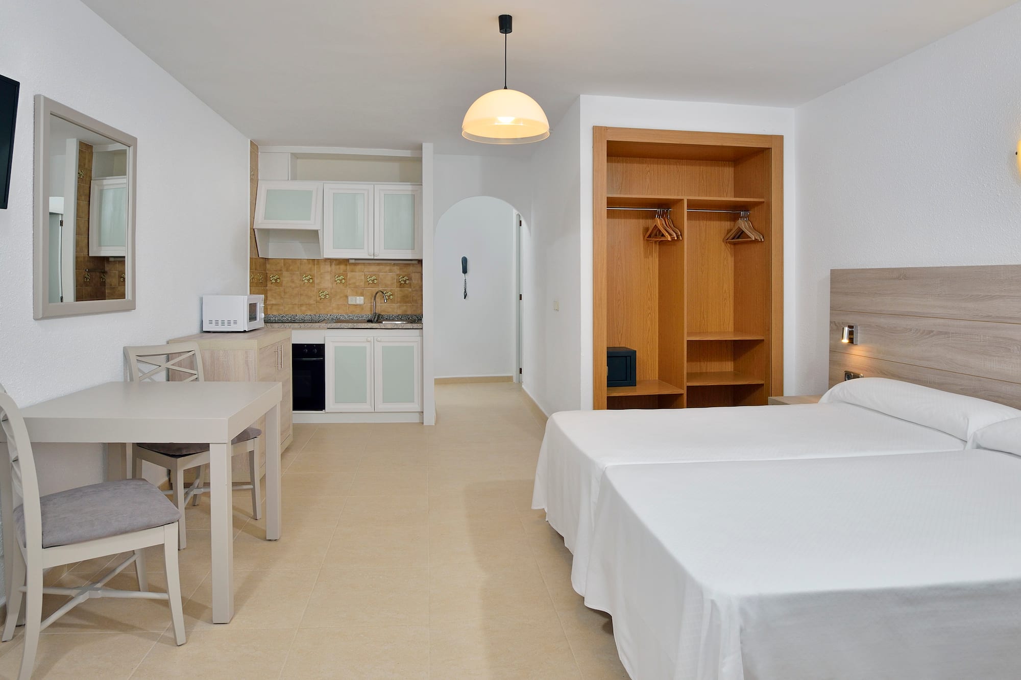 a room with a bed and a table and chairs