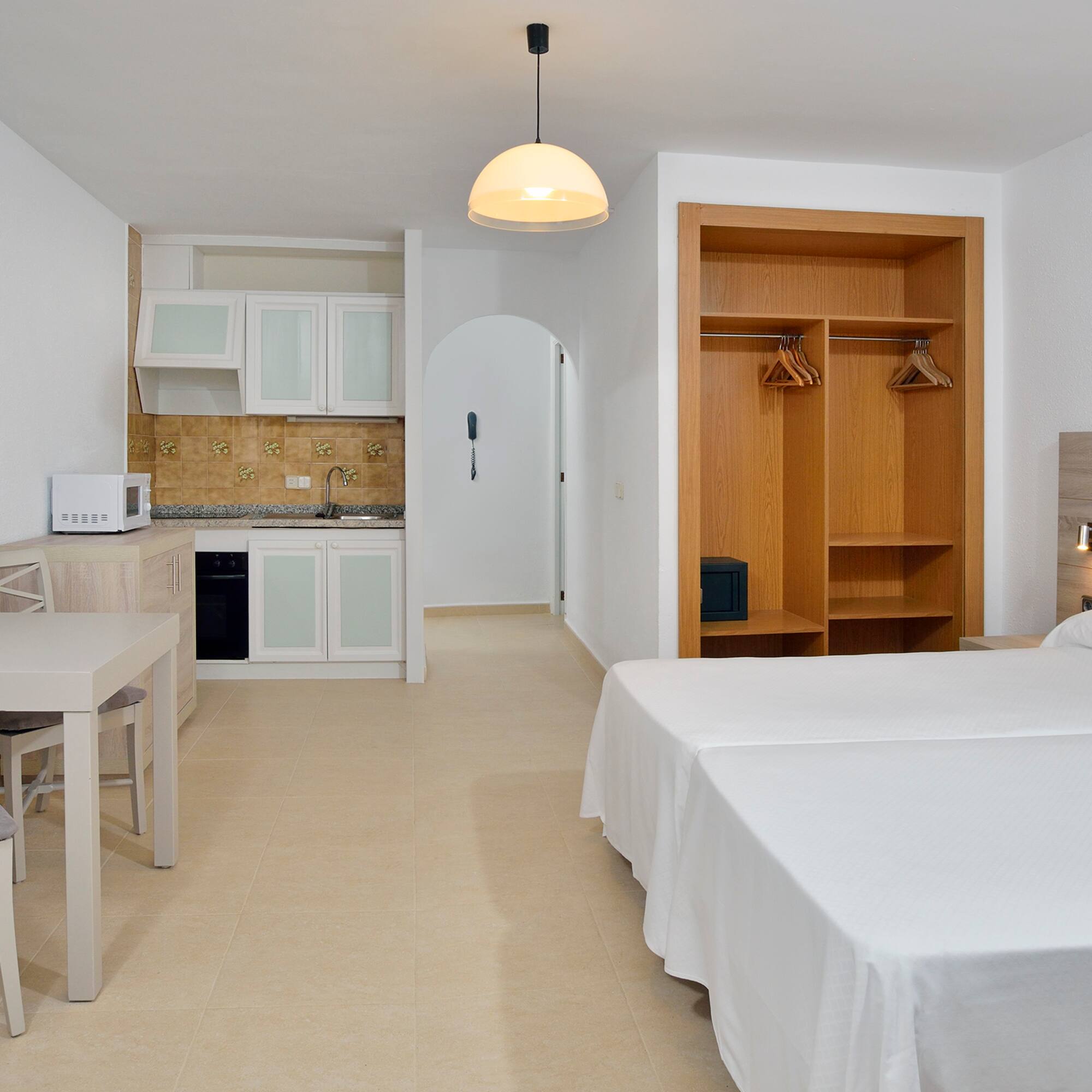 a room with a bed and a table and chairs