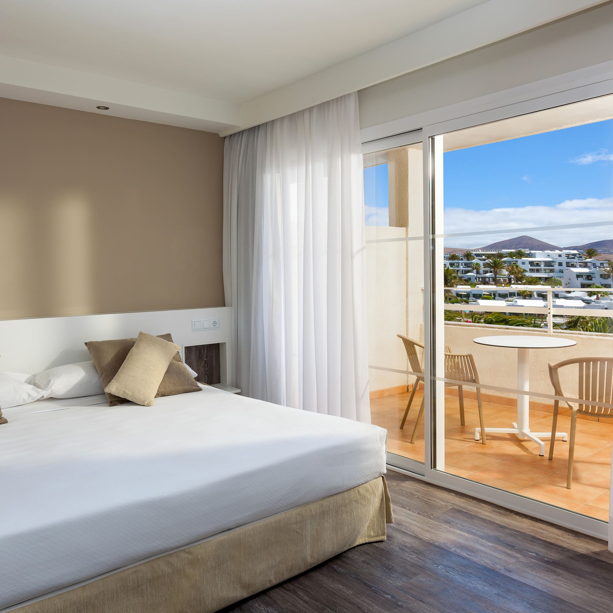 a bedroom with a glass door and a table and chairs