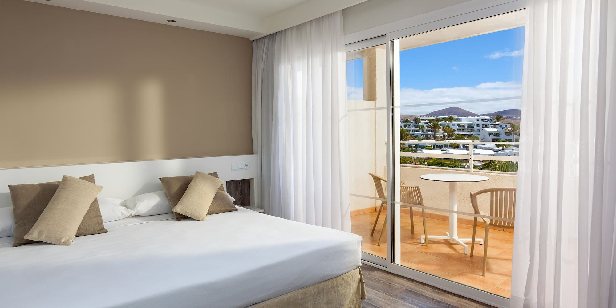 a bedroom with a glass door and a table and chairs