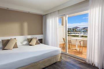 a bedroom with a glass door and a table and chairs