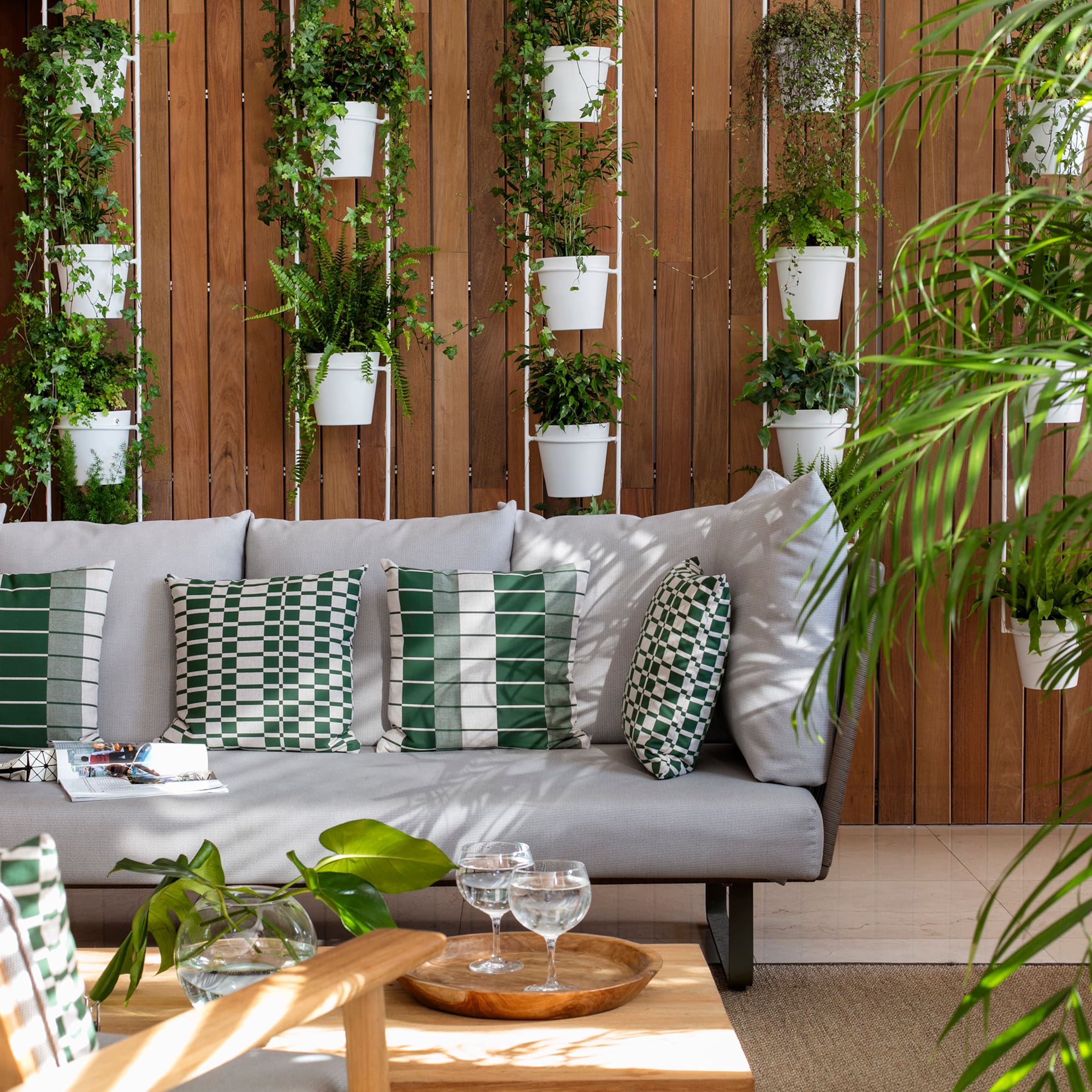 a couch with pillows and a table with plants from it