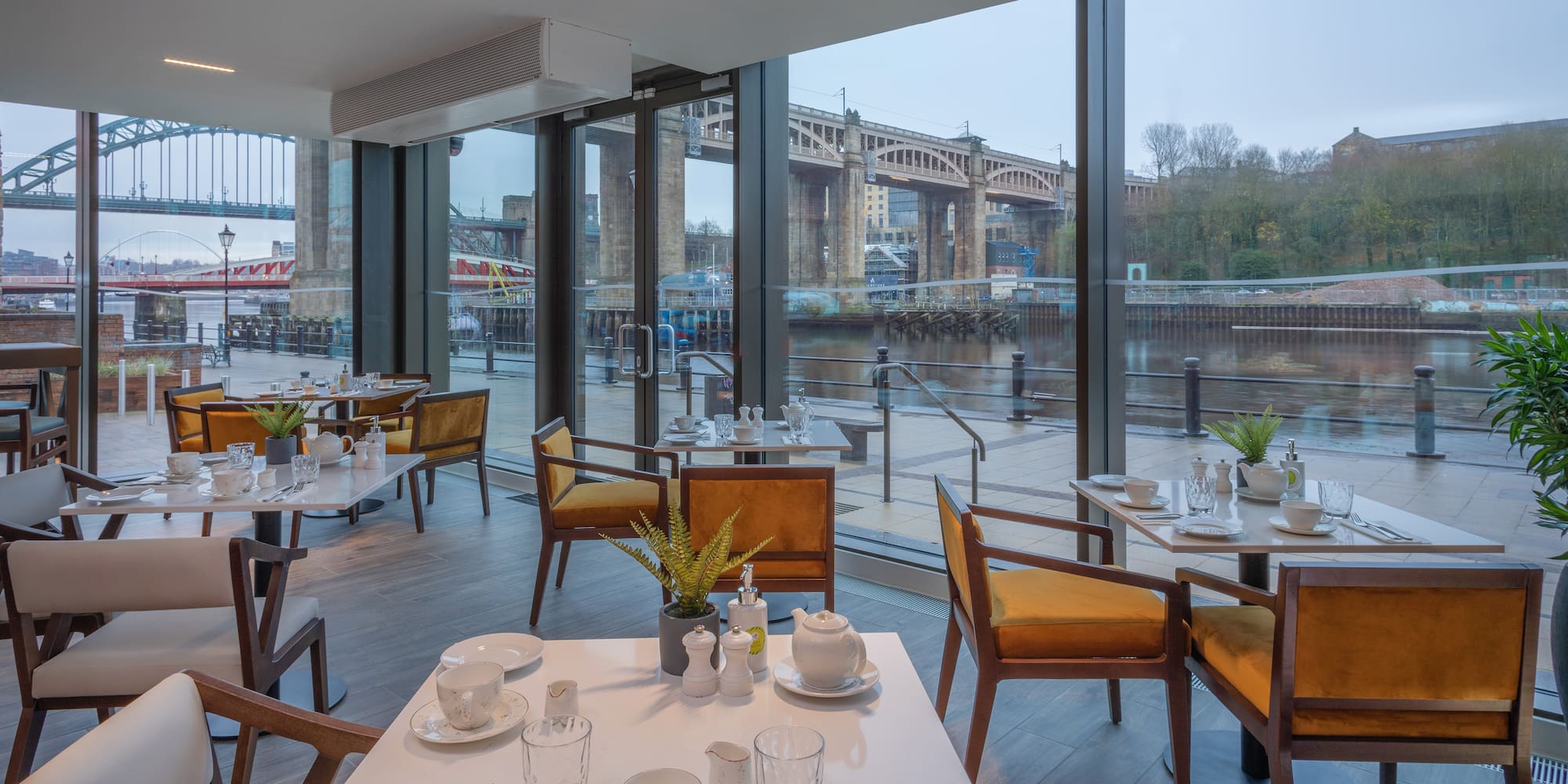 Waterfront restaurant in Newcastle overlooking Tyne Bridges, set tables.