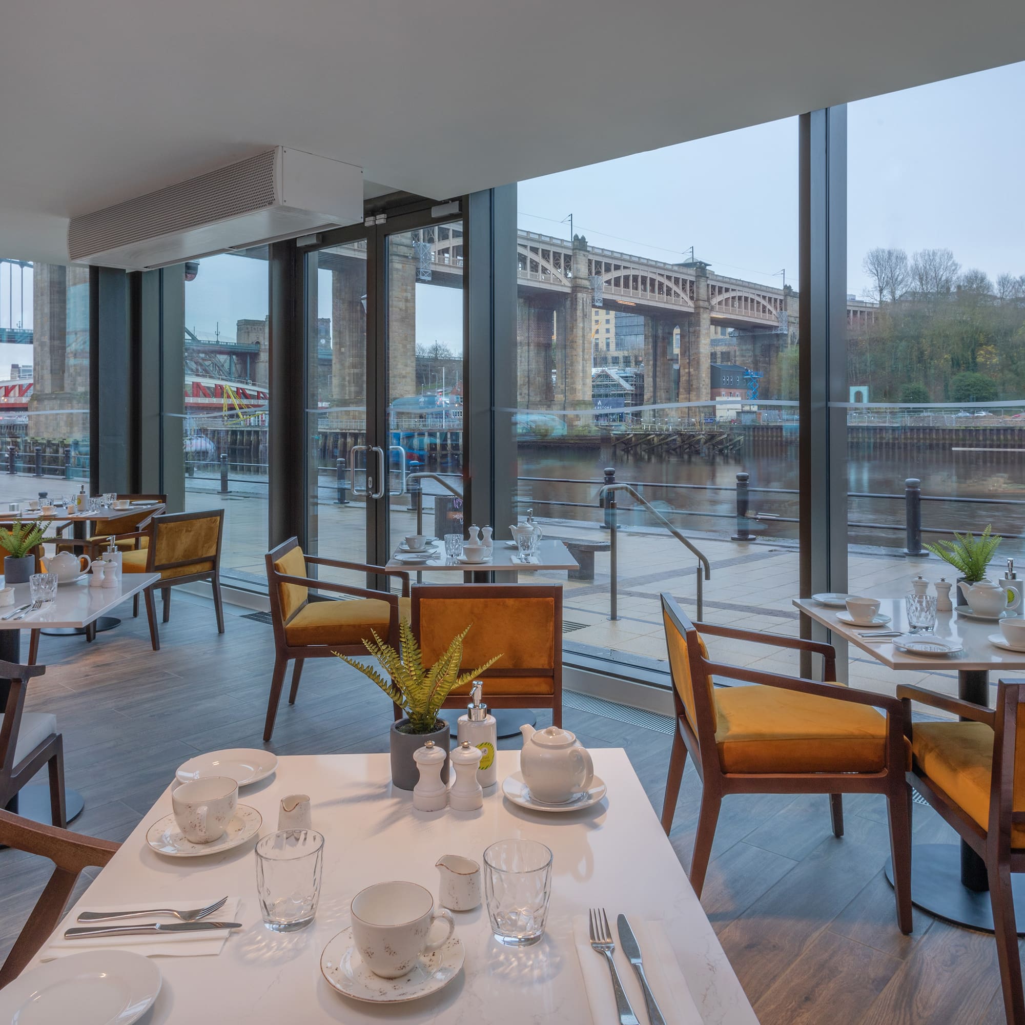 Waterfront restaurant in Newcastle overlooking Tyne Bridges, set tables.