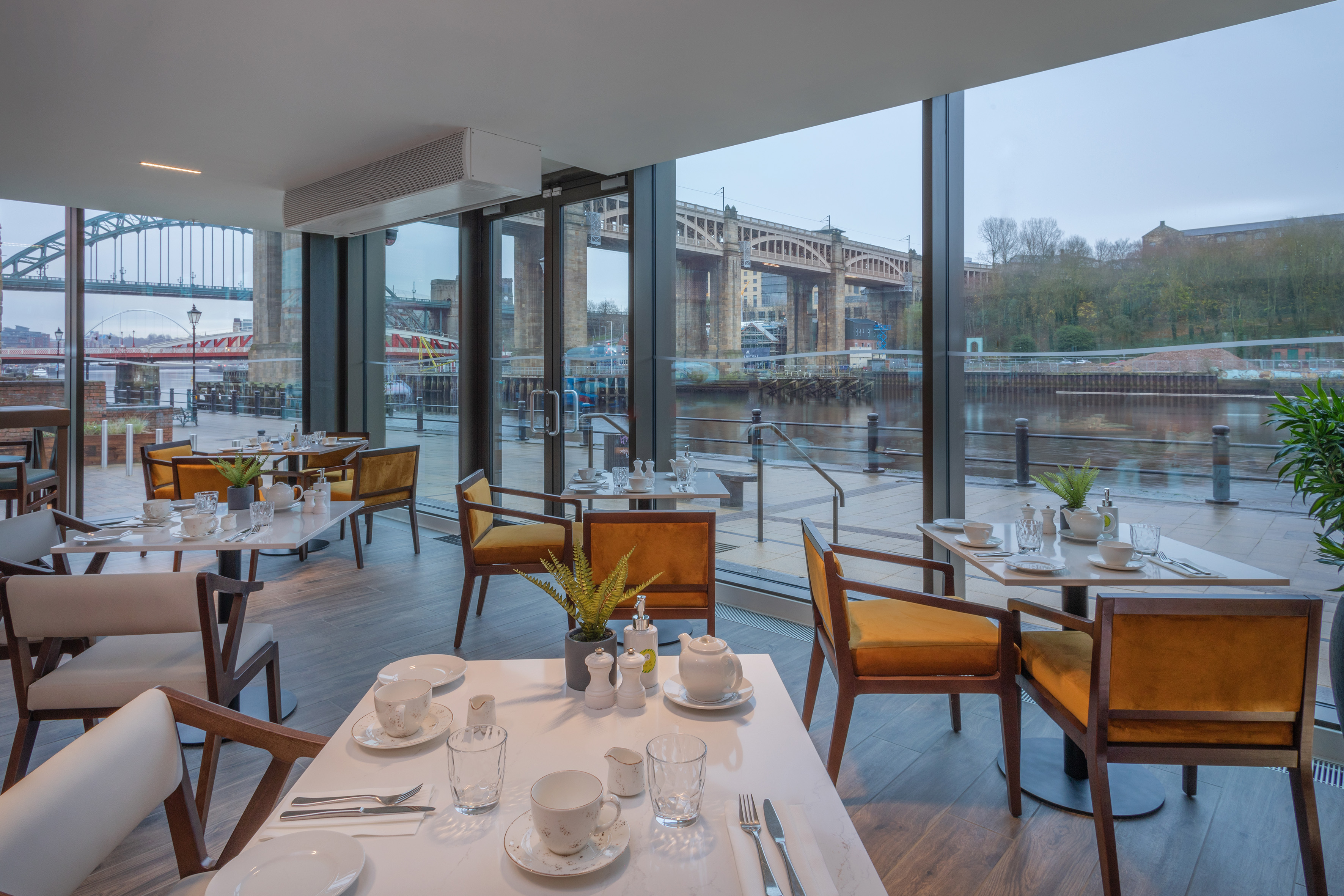 Waterfront restaurant in Newcastle overlooking Tyne Bridges, set tables.