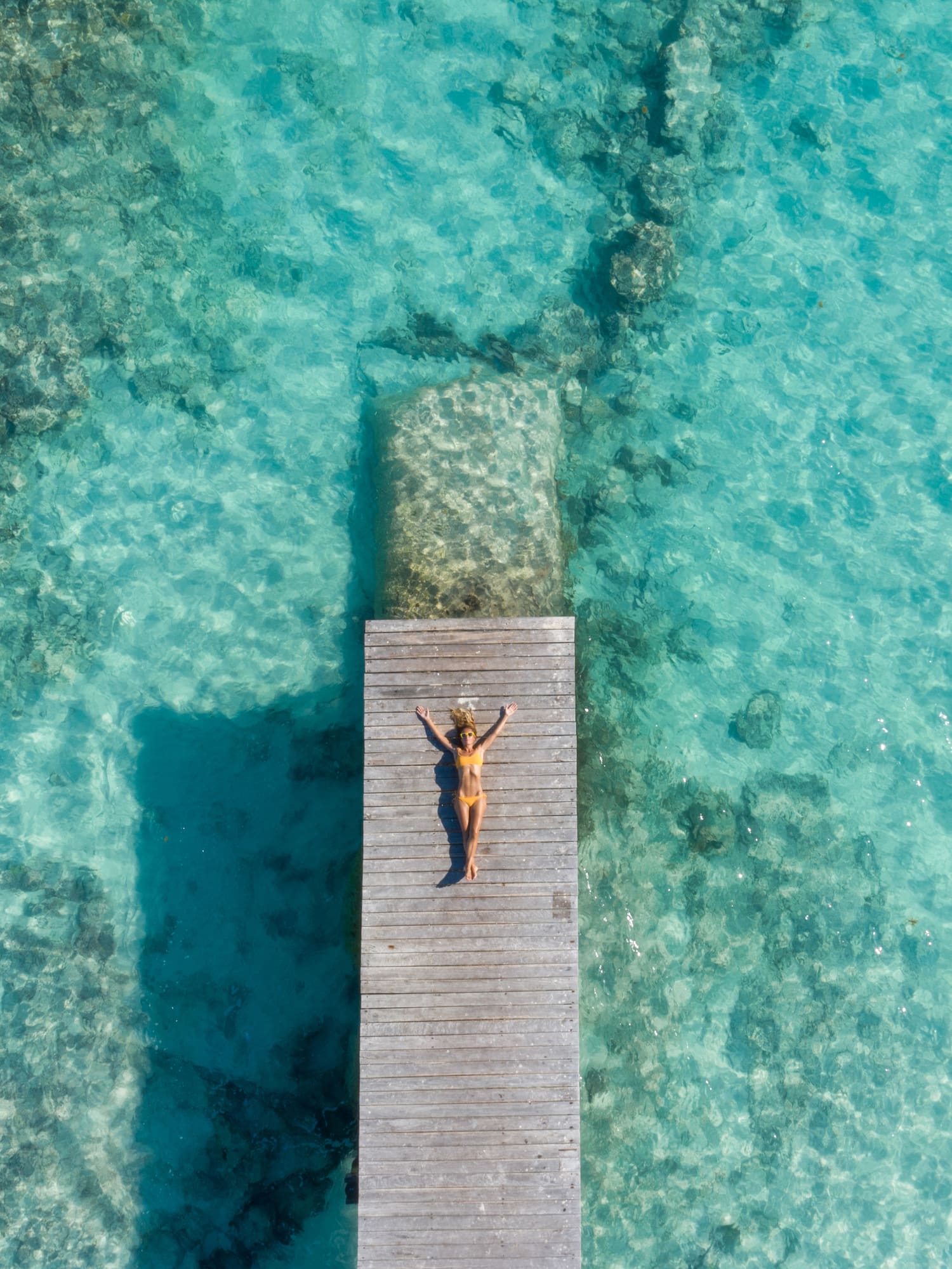 a woman lying on a dock in the water