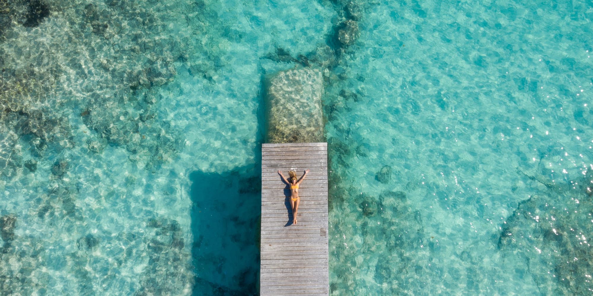 a woman lying on a dock in the water